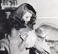 a black and white photo of a woman sitting on a couch