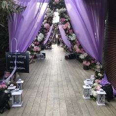 a walkway decorated with purple drapes and flowers