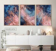 two paintings are hanging on the wall above a white dresser and sideboard in a living room