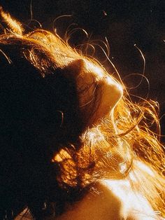 the back of a woman's head with her hair blowing in the wind at night