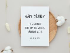 a birthday card sitting on top of a wooden plate next to cotton balls and flowers