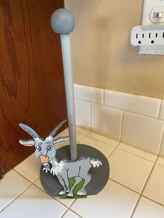 a toilet paper dispenser in the shape of a donkey on a tile floor