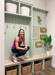 a woman squatting on top of a bench in a room with baskets and shelves