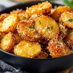 fried potatoes with parmesan cheese in a black bowl