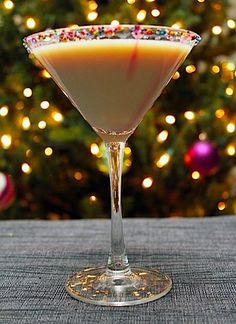 a martini sitting on top of a table next to a christmas tree