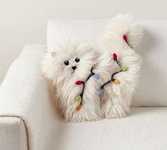 a white couch with two stuffed animals on it's back legs and lights attached to the arms