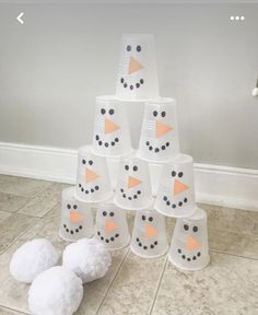 snowmen made out of paper cups sitting on the floor next to some white balls