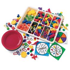 a tray filled with lots of colorful toys and magnets next to a red plate