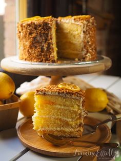 a slice of cake on a plate with a fork and some lemons in the background