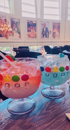 two cocktails sitting on top of a wooden table