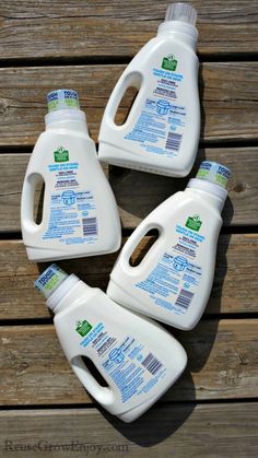 four gallon jugs of hand sanitizer sitting on top of a wooden table