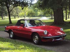 a red convertible car parked on the side of a road