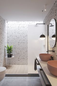 a bathroom with two sinks and a bathtub in the corner, along with a plant