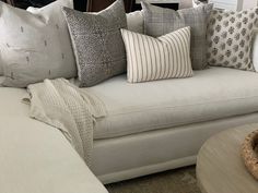 a white couch with many pillows on it