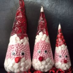 three candy cones decorated like santas with eyes and noses on them, sitting next to each other