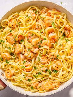 pasta with shrimp and parsley in a skillet on a white surface, ready to be eaten