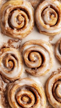 cinnamon rolls in a baking pan with icing on top, ready to be baked