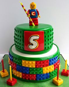 a birthday cake made to look like legos with the number three on top and letters that spell out