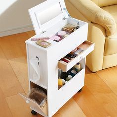 a small white vanity on wheels with makeup and toiletries in the bottom drawer next to it