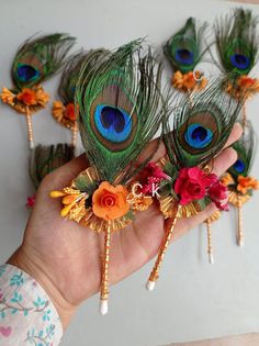 there are peacock feathers and flowers in the hand