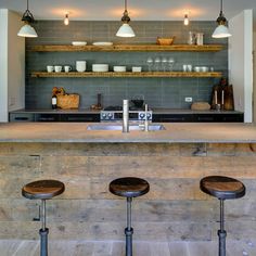 three stools sit in front of an island counter