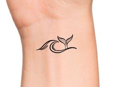 a small tattoo on the wrist of a woman