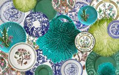 many plates are arranged together on a table top with blue and green designs in the middle