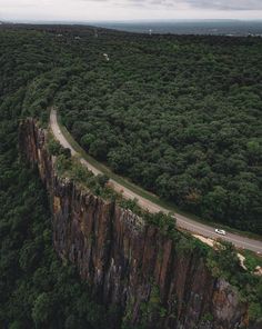 an aerial view of a road in the middle of a forest