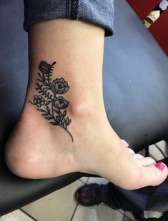 a woman's foot with a flower tattoo on it