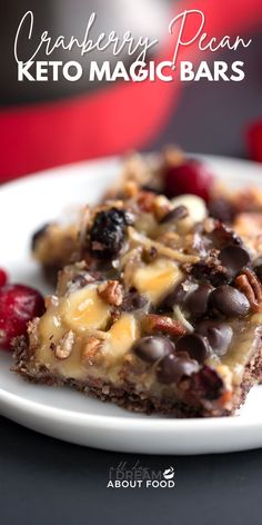 a close up of a plate of food on a table with text above it that reads cranberry pecan keto magic bars