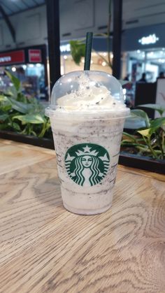 a starbucks drink sitting on top of a wooden table