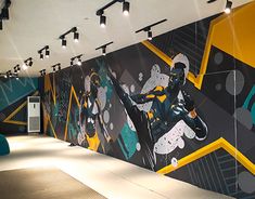 a large mural on the side of a wall in a room with black and yellow accents