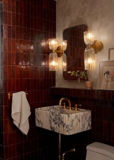 a bathroom with a sink, mirror and toilet in it's corner next to a tiled wall