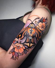 a woman's arm with an owl and flowers tattoo on it