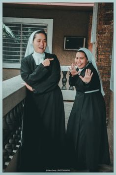 two women dressed in nun costumes standing next to each other with their hands together and smiling