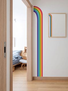 an open door leading to a bedroom with a rainbow painted on the wall