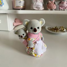 two stuffed animals sitting on top of a table