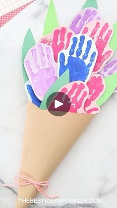 a paper cone with handprints on it sitting on top of a marble surface