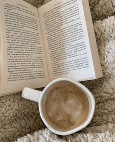 an open book and cup of coffee on a blanket