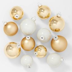 gold and white ornaments are arranged on a white surface