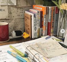 a bunch of papers and pens on a desk with a rubber ducky toy next to them