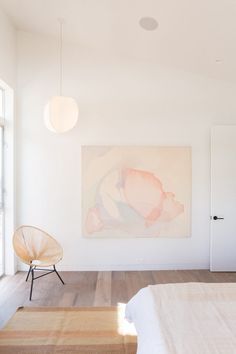 a bedroom with white walls and wooden floors