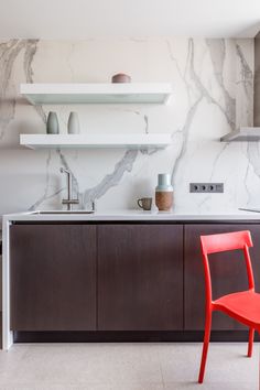 a red chair sitting next to a kitchen counter