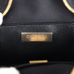 This Chanel quilted CC star bag is in black satin fabric with light gold hardware and features an exterior back slip pocket, dual zip top closure and an interwoven light gold chain link and black satin leather shoulder strap.The interior is lined in black grossgrain canvas and black leather with two open slip pockets on each wall.Collection: 24C (RFID)Origin: FranceCondition: New and never worn Accompanied by: Chanel box, Chanel dustbag, retail UPC, RFIDMeasurements: 8.5" width x 7.25" height x 2" depth; 19" strap drop Evening Top Handle Bag With Gold-tone Logo, Luxury Business Bags With Gold-tone Logo Plaque, High-end Evening Bag With Gold-tone Logo Plaque, High-end Evening Bags With Gold-tone Logo Plaque, High-end Evening Bags With Zipper Closure, High-end Evening Bags With Zipper, Luxury Evening Shoulder Bag With Zipper Closure, Star Bag, Black Satin Fabric