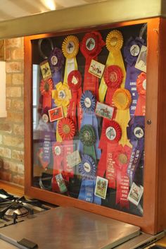 a kitchen stove top under a display case filled with award ribbons and awards on it