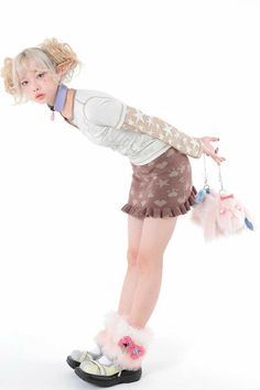 a young woman in short skirt and boots holding two pom poms