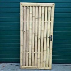 a bamboo door is shown in front of a green wall