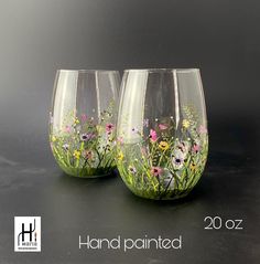 two hand painted wine glasses with wildflowers and daisies on the stemings