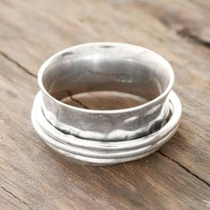 three silver rings sitting on top of a wooden table