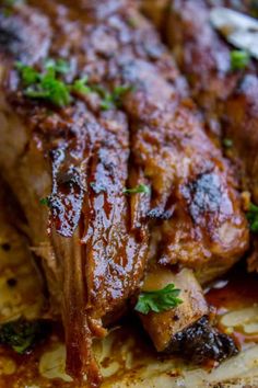 a close up of some meat on a plate with sauce and garnishes